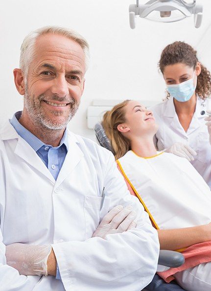 Dentist and dental team member treating dentistry patient