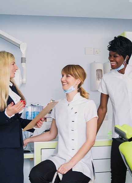 Dentist and dental team member talking to administrative team member