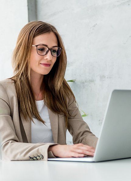 Woman in glasses looking at laptop